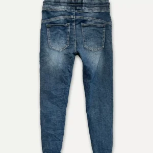 The Cozy elastisk byxa - Jeans är blå denimbyxor, visade bakifrån med två fickor och en elastisk linning, liggande platt på en vit bakgrund.