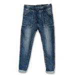 Cozy elastisk byxa - Jeans är blå denimjeans med upprullade muddar, stora påsydda framfickor, synlig knapp och linning, platta mot vit bakgrund.