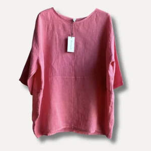 Linneblus - ELBA är en löst sittande rosa linneblus med trekvartsärmar som visas på galge mot en enfärgad bakgrund. En vit etikett är fäst vid kragen.