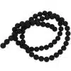 Black beaded necklace coiled into a loose spiral on a white background