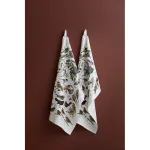 Two white towels with a colorful bird illustration hang on a brown wall.