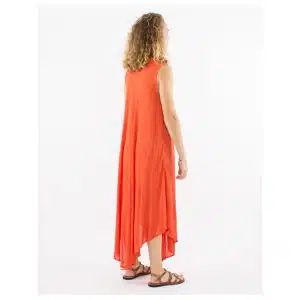 Woman in an orange sleeveless maxi dress with a high-low hem, standing sideways in brown sandals.