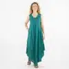 Woman wearing a teal sleeveless maxi dress with embroidery, standing against a white studio background with a relaxed pose.