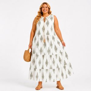 Plus-size woman wearing a white sleeveless maxi dress with a damask-style pattern, carrying a woven straw handbag.