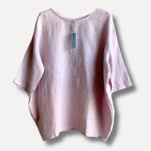 Light pink linen blouse with a blue tag hanging from the back neckline, photographed against a pale background