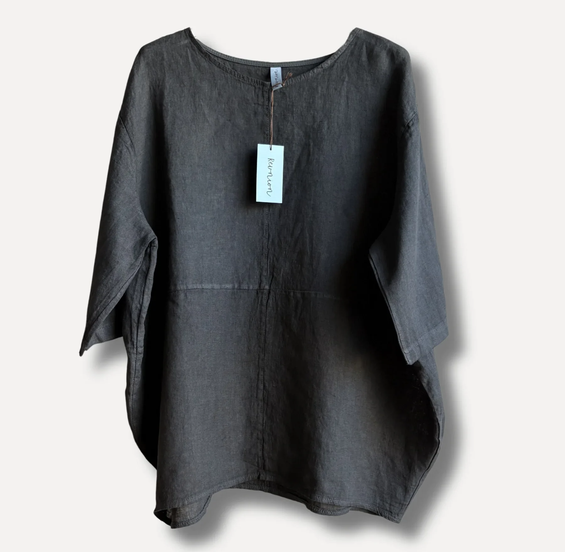 Dark gray linen blouse with a light blue tag attached at the neckline, long sleeves, and a curved hem visible on a neutral background.