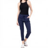 Full-body view of a woman in a black sleeveless top, navy jogger pants with rolled cuffs, and white sneakers.